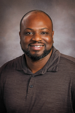 Man with beard in gray polo shirt