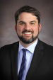 photo of white man with dark hair, beard, tie and sport coat