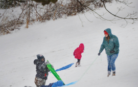 photo of First City Connection magazine cover with children carrying sleds up a snowy slope