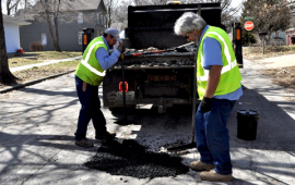 City street workers fix pot holes in March 2019