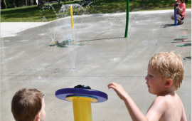 Photo of the front page of the newsletter shows a photo of two young boys pushing the button at the Leavenworth Splash pad