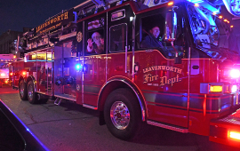 santa and child wave from inside a fire truck