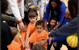 cover of First city connection magazine with photo of children putting their hands in a circle with a coach with a basketball