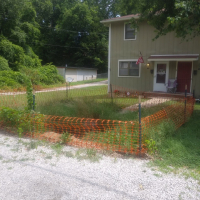 Photo of house with a sink hole blocked off with orange fencing