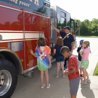 children looking at fire truck