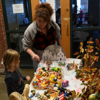 Mom and daughter shop crafts at a holiday market