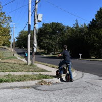 Child lifts bike over curb without ADA ramp