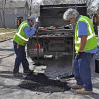 City workers do street patching repair along Ottawa Street.