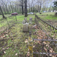 set of grave stones in a field surrounded by a fence