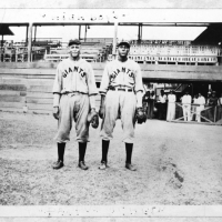 Two black men in Giants baseball uniforms on a baseball field