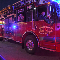 santa and child wave from inside a fire truck