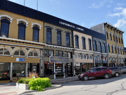 Photo shows historic buildings along a City street with sign "Leavenworth Landing"