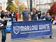 Children carry "Marlow White" banner in 2023 Leavenworth County Veterans Day Parade
